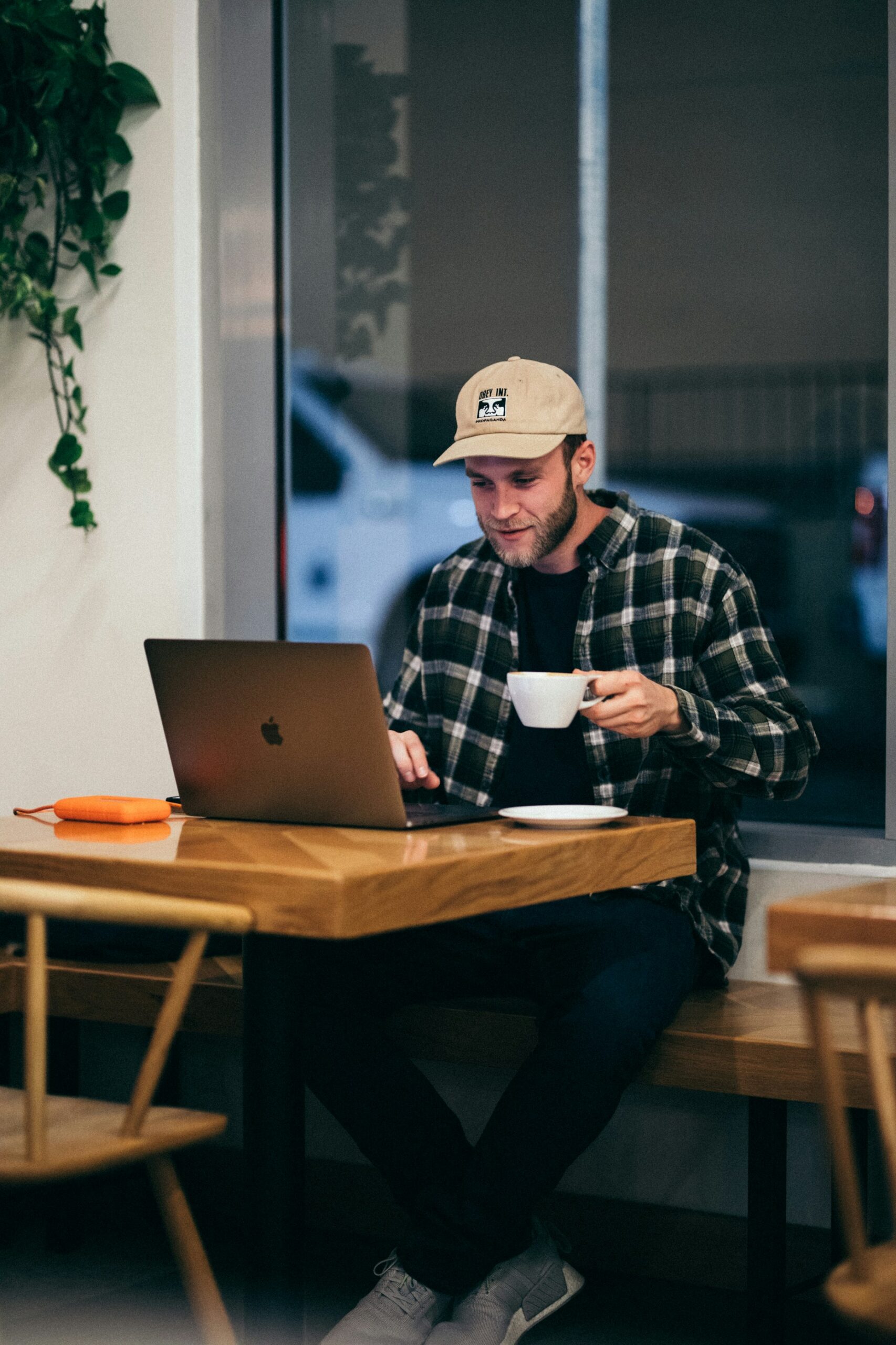 A man behind his laptop drinking coffe looking happy because Antminer Z15 Pro and Z15 are Profitable Again in 2025 credit: kyle-loftus-PFC2fY9LE_g-unsplash